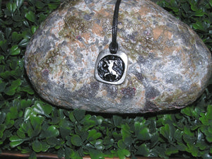Year of the sheep or goat or ram, Chinese zodiac animal sign pendant necklace for unisex, squarish pendant with black background, cotton cord style. (picture taken on a background with a rock)