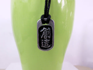 Kanji symbol for creativity pendant with black background, black cord necklace style. 